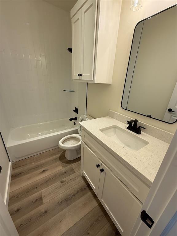 full bathroom featuring wood-type flooring, vanity, shower / bathtub combination, and toilet