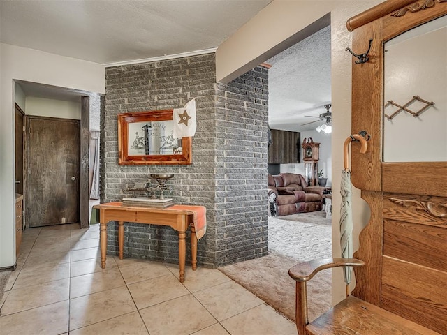 corridor featuring light tile patterned flooring, brick wall, and a textured ceiling