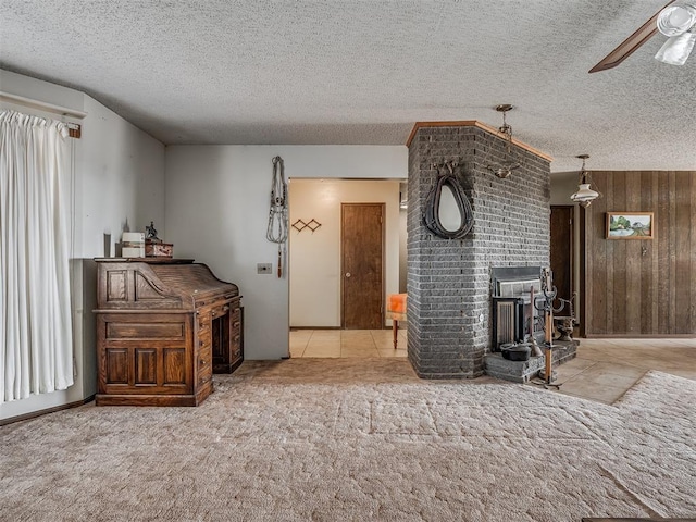 carpeted living room with ceiling fan, wooden walls, and a textured ceiling