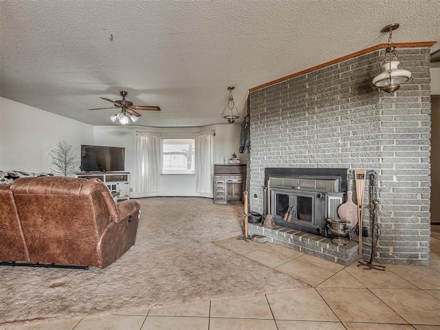 living room with a brick fireplace, ceiling fan, a textured ceiling, and carpet flooring