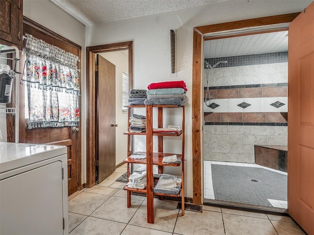 interior space with washer / clothes dryer, a textured ceiling, and light tile patterned floors