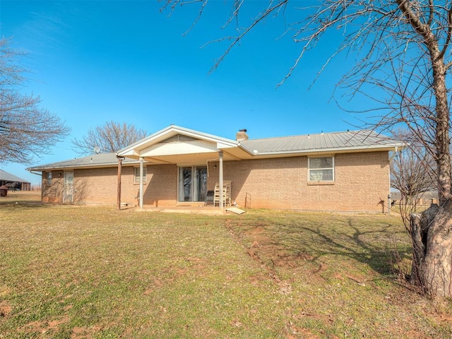 rear view of house featuring a lawn