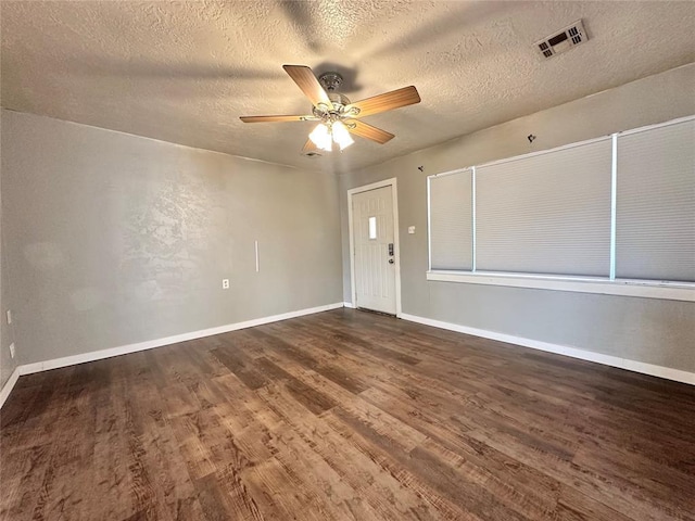 empty room featuring a textured ceiling, dark hardwood / wood-style floors, and ceiling fan