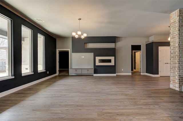 1548 NW 175th Ct, Edmond, OK 73012 - unfurnished living room featuring a chandelier, wood finished floors, and baseboards