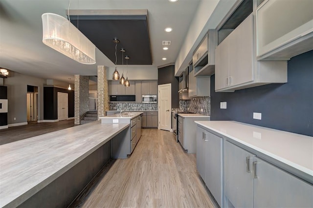 1548 NW 175th Ct, Edmond, OK 73012 - kitchen featuring light countertops, stainless steel appliances, light wood finished floors, backsplash, and gray cabinets