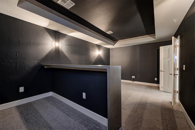 1548 NW 175th Ct, Edmond, OK 73012 - carpeted home theater room with a tray ceiling, baseboards, and a textured wall