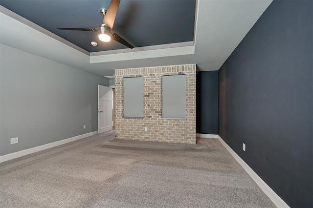 1548 NW 175th Ct, Edmond, OK 73012 - carpeted spare room featuring a tray ceiling, a ceiling fan, and baseboards