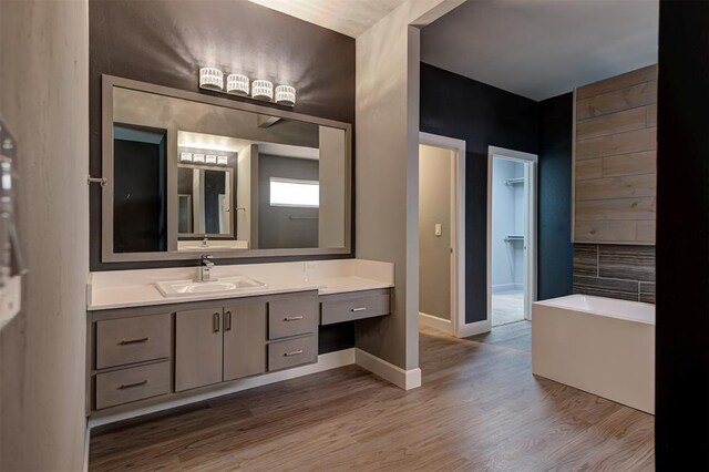 1548 NW 175th Ct, Edmond, OK 73012 - bathroom featuring a freestanding bath, wood finished floors, vanity, and baseboards