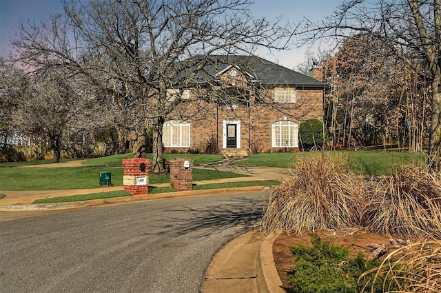 view of front of property featuring a front yard and brick siding