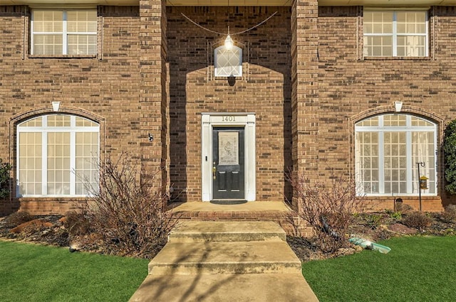 doorway to property featuring brick siding