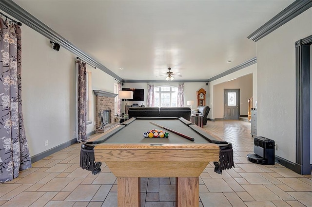 rec room featuring ornamental molding, a fireplace, light tile patterned floors, baseboards, and ceiling fan