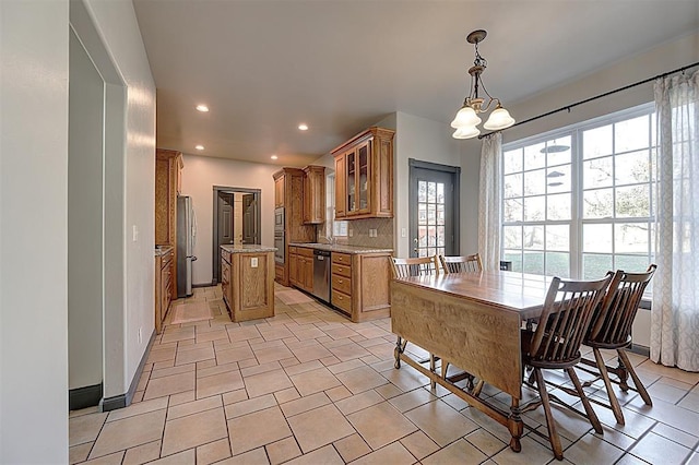 kitchen with brown cabinets, tasteful backsplash, a kitchen island, stainless steel appliances, and glass insert cabinets