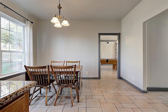 dining area featuring a wealth of natural light, baseboards, and a notable chandelier