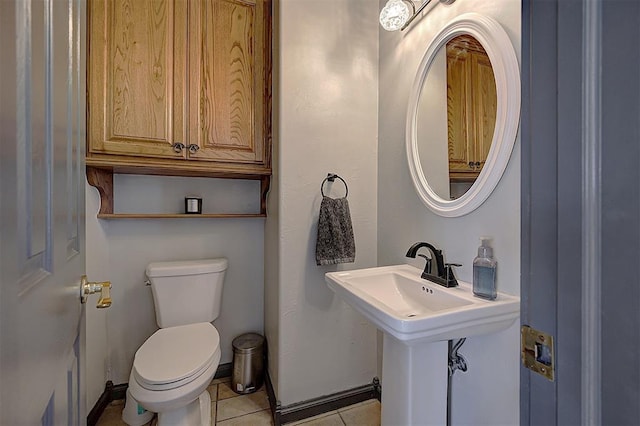 bathroom with a sink, baseboards, toilet, and tile patterned flooring