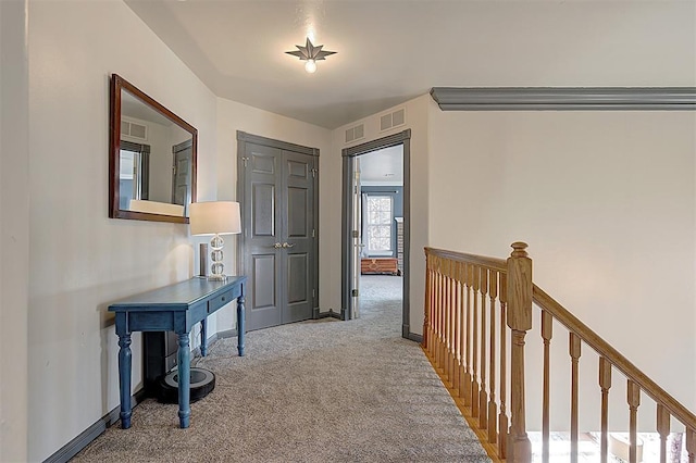 hall featuring carpet flooring, an upstairs landing, and visible vents