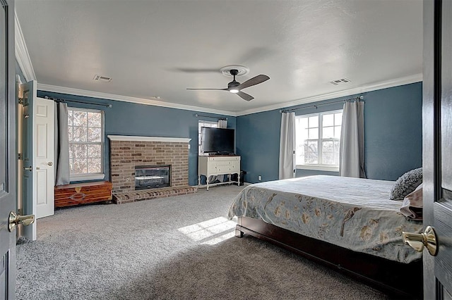 carpeted bedroom with visible vents, a fireplace, and crown molding