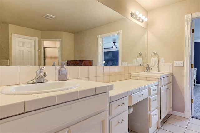 bathroom with a sink, visible vents, double vanity, and tile patterned flooring