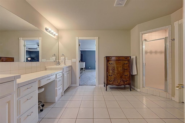 bathroom featuring visible vents, a shower stall, tile patterned flooring, baseboards, and vanity