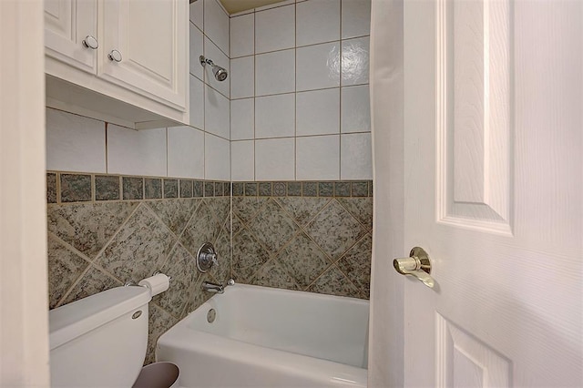 full bathroom with tile walls, toilet, and shower / bathtub combination