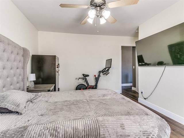 bedroom featuring a ceiling fan, baseboards, and wood finished floors