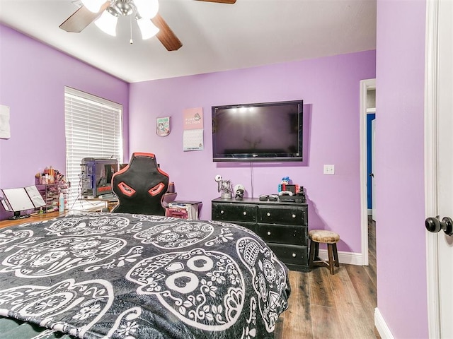 bedroom with a ceiling fan, wood finished floors, and baseboards