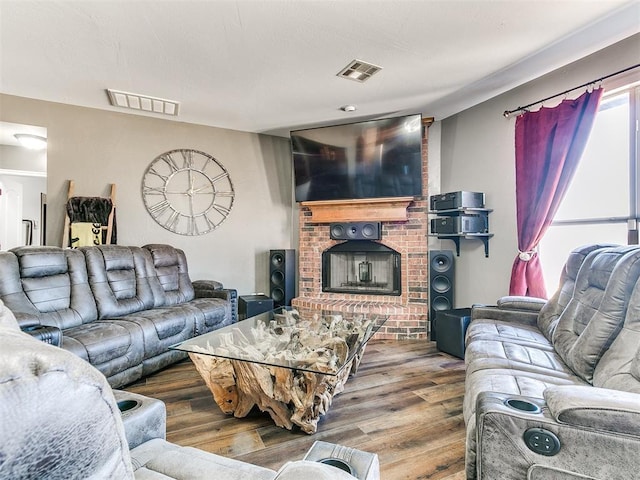 living area with visible vents, a fireplace, and wood finished floors