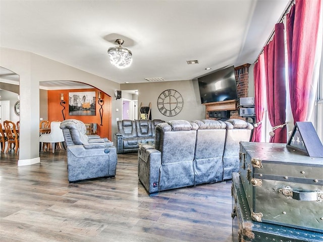 living room with visible vents, wood finished floors, and arched walkways