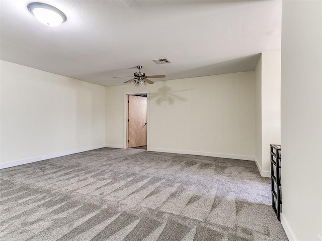 spare room featuring a ceiling fan, visible vents, carpet floors, and baseboards