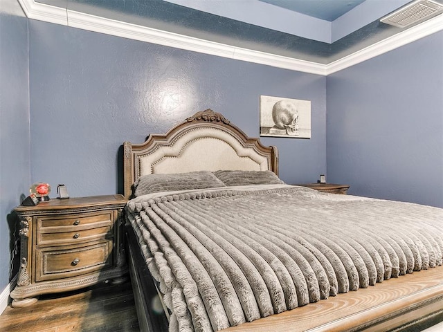 bedroom featuring visible vents, wood finished floors, and crown molding