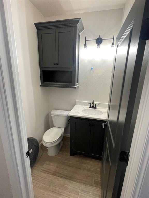 bathroom featuring vanity, hardwood / wood-style floors, and toilet