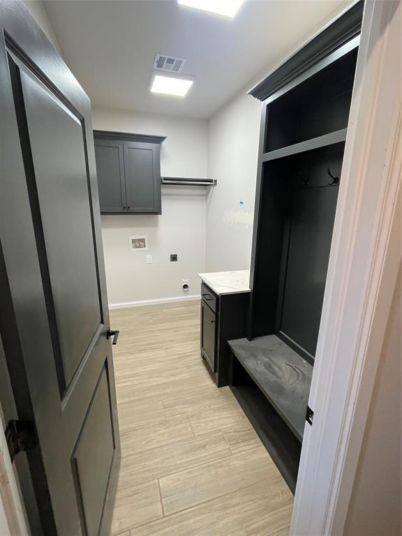 laundry area featuring washer hookup, light hardwood / wood-style floors, and electric dryer hookup