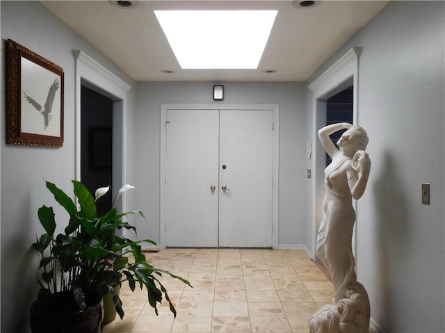 tiled entryway featuring a skylight