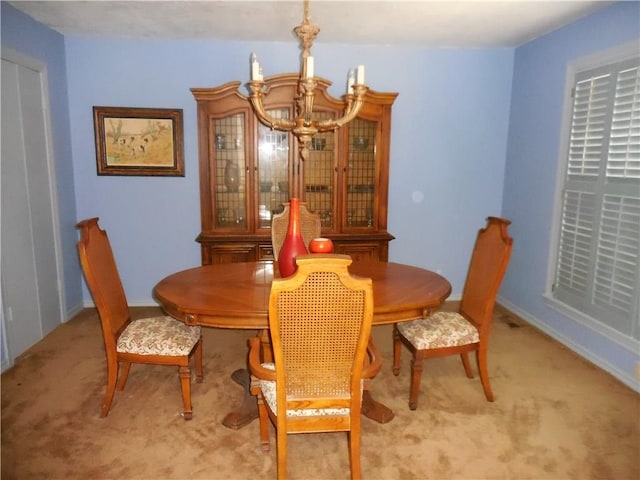 carpeted dining room featuring a chandelier