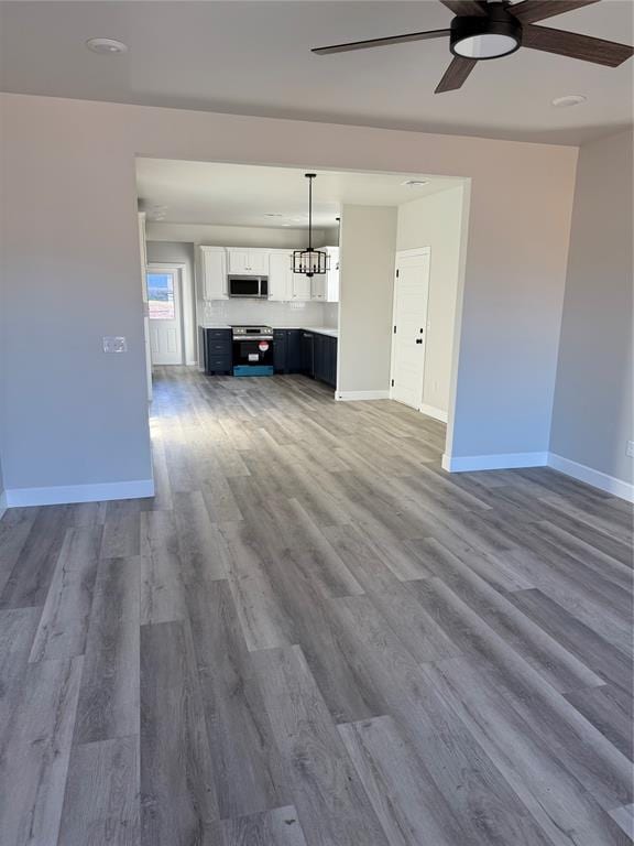 unfurnished living room with hardwood / wood-style flooring and ceiling fan