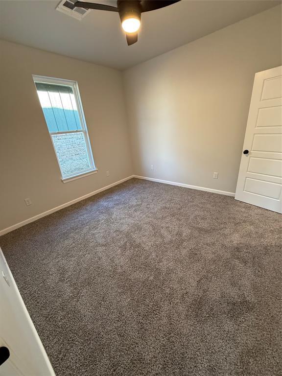 spare room featuring ceiling fan and carpet floors