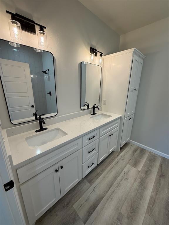 bathroom with walk in shower, vanity, and hardwood / wood-style floors