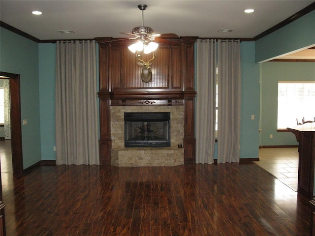 unfurnished living room featuring hardwood / wood-style floors, a fireplace, ornamental molding, and ceiling fan