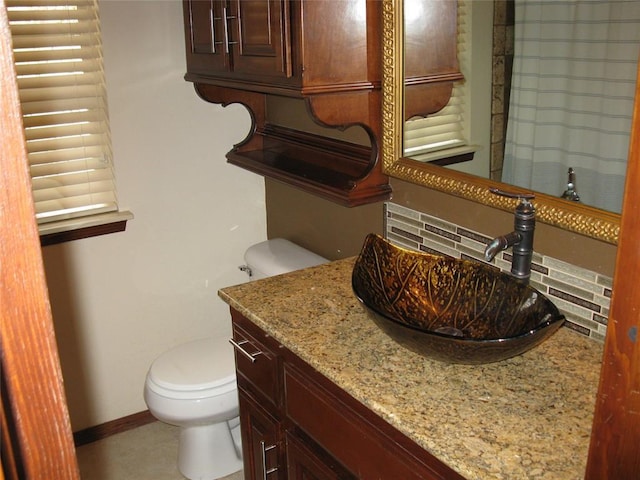 bathroom featuring vanity, backsplash, tile patterned floors, and toilet