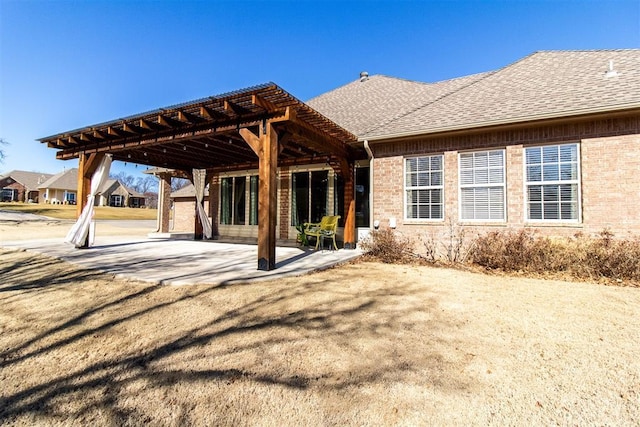 back of property with a pergola and a patio area