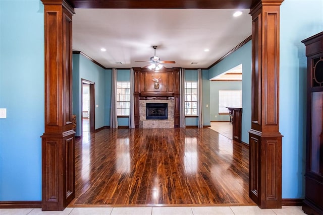 unfurnished living room featuring ceiling fan, ornamental molding, decorative columns, and light hardwood / wood-style flooring