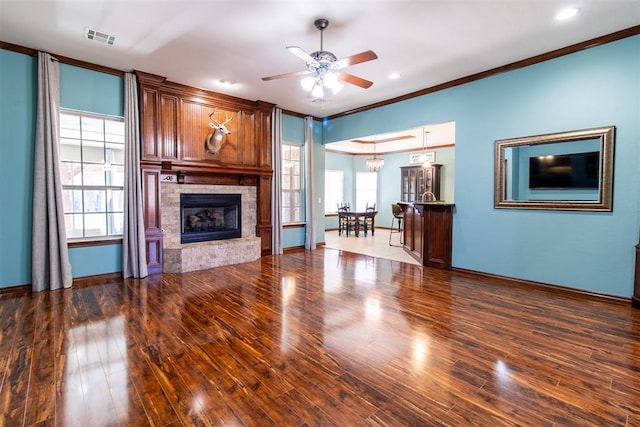 unfurnished living room featuring a fireplace, ornamental molding, dark hardwood / wood-style flooring, and a wealth of natural light