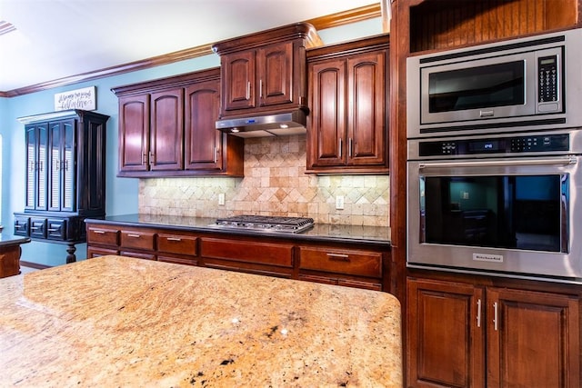 kitchen featuring tasteful backsplash, ornamental molding, appliances with stainless steel finishes, and dark stone countertops