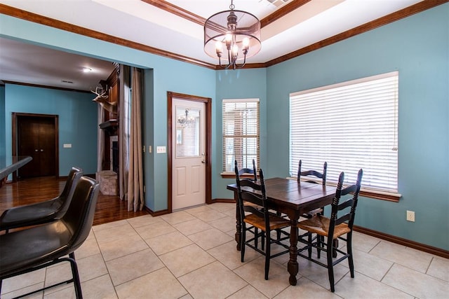 dining area featuring ornamental molding, a chandelier, a raised ceiling, and light tile patterned floors