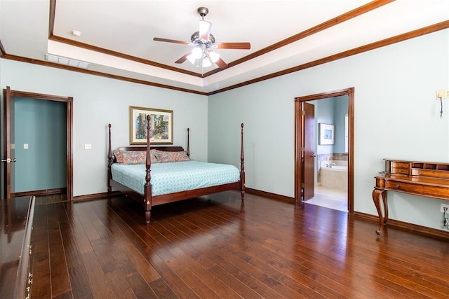 bedroom with ornamental molding, dark wood-type flooring, connected bathroom, and a tray ceiling