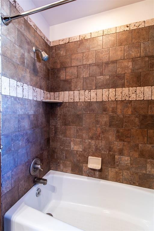 bathroom featuring tiled shower / bath