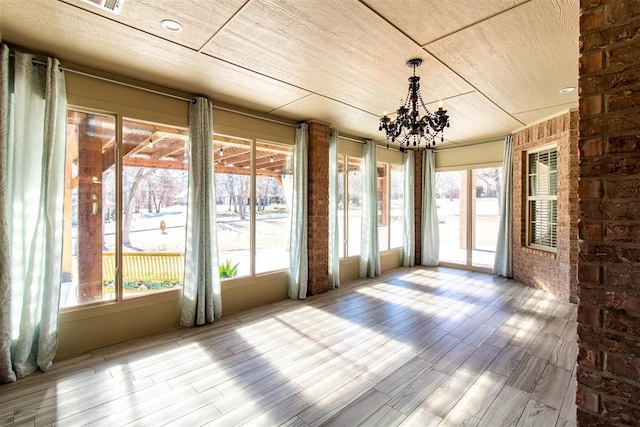 unfurnished sunroom featuring a notable chandelier and a wealth of natural light