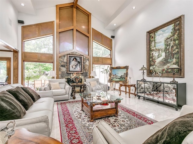 living room with a high ceiling and a stone fireplace