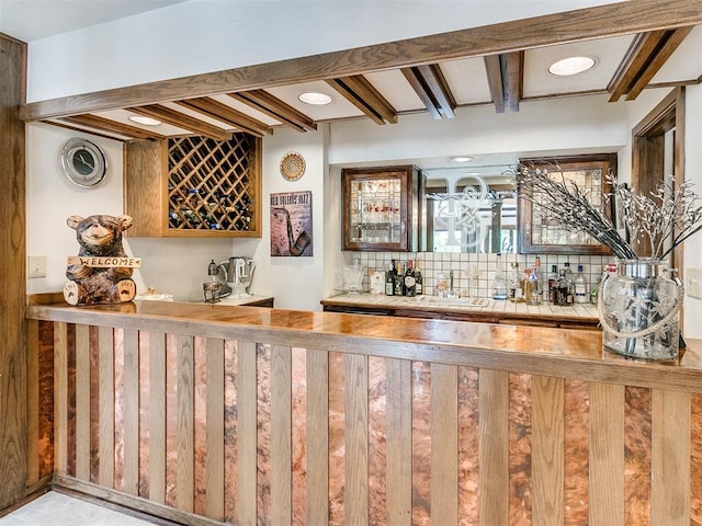 bar with beam ceiling, sink, and decorative backsplash