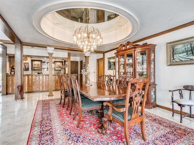 dining space with an inviting chandelier, ornamental molding, a raised ceiling, and ornate columns