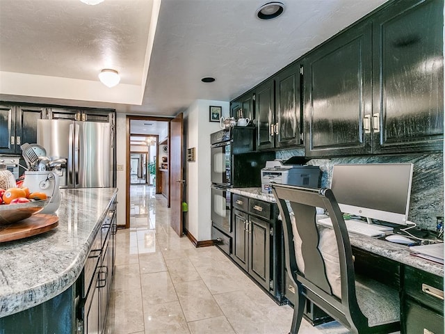 kitchen with stainless steel refrigerator with ice dispenser, black double oven, and decorative backsplash